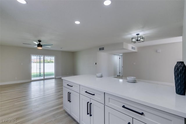 kitchen with light wood finished floors, visible vents, open floor plan, light countertops, and recessed lighting