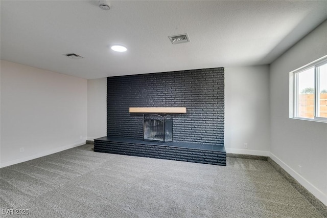 unfurnished living room with visible vents, carpet flooring, a brick fireplace, and baseboards