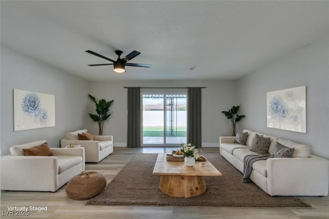 living room featuring a ceiling fan, wood finished floors, and baseboards