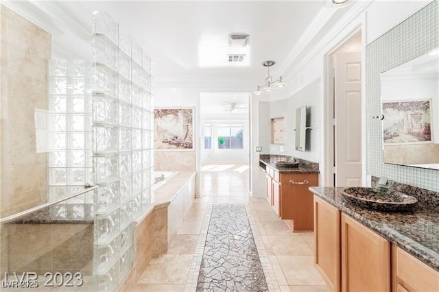 bathroom featuring two vanities, visible vents, tiled shower, a bath, and crown molding