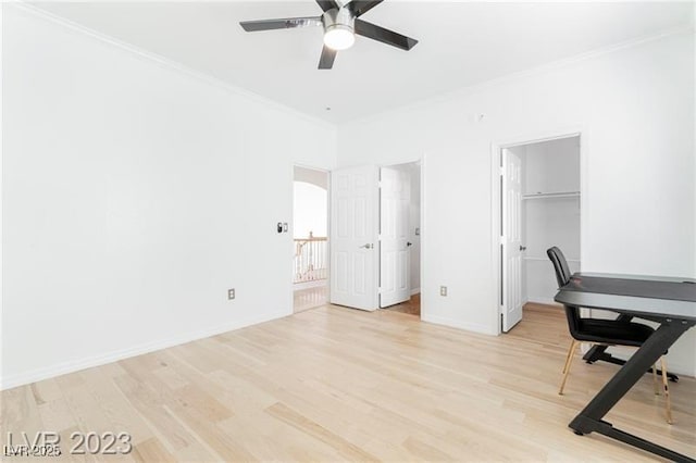 office space featuring light wood-style floors, crown molding, baseboards, and a ceiling fan