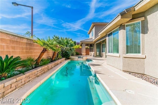 view of pool with a patio area, a fenced backyard, and a pool with connected hot tub