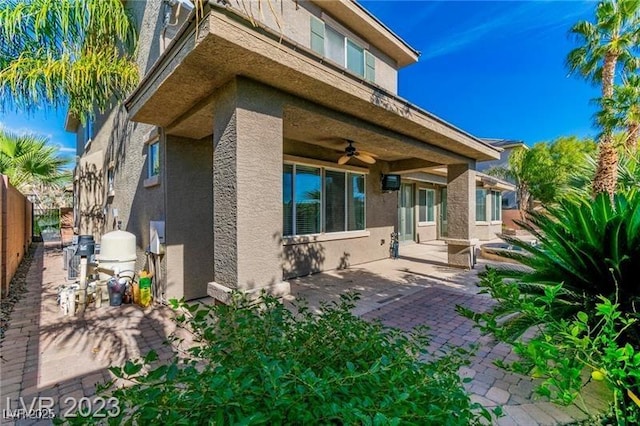 back of house with a patio area, fence, a ceiling fan, and stucco siding