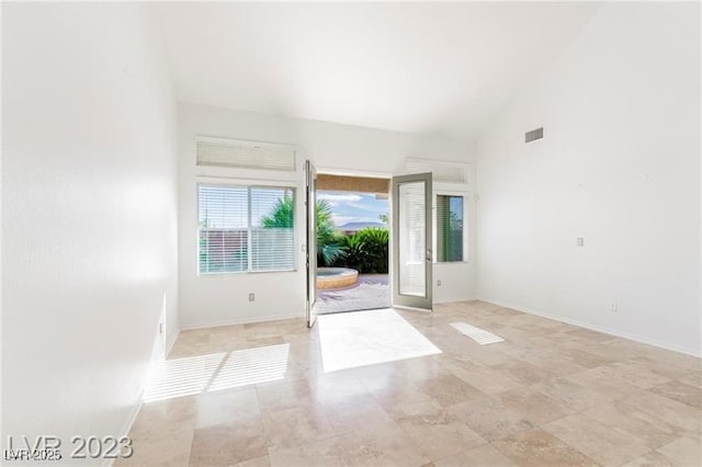 interior space featuring high vaulted ceiling, visible vents, and baseboards