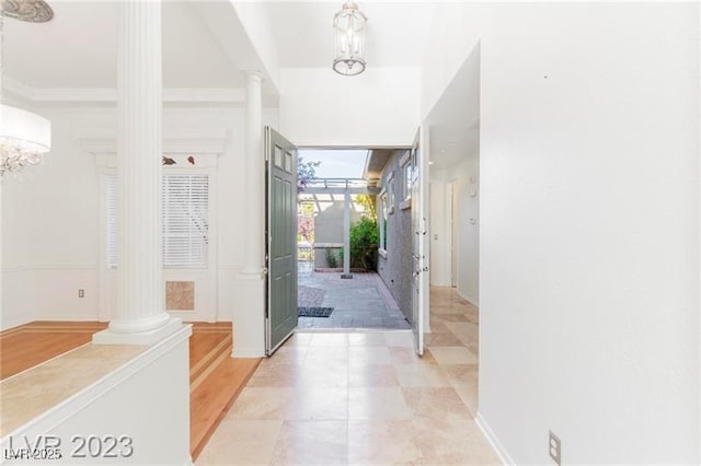 entrance foyer with decorative columns and crown molding