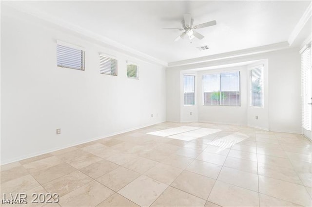 unfurnished room with a ceiling fan, a tray ceiling, visible vents, and baseboards