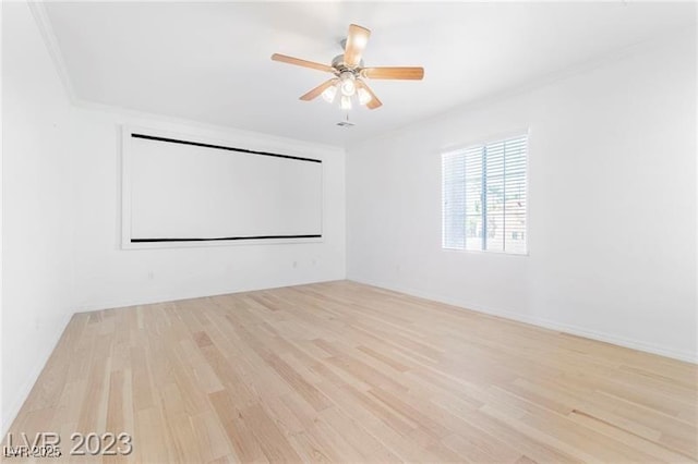 empty room featuring ceiling fan, crown molding, and wood finished floors