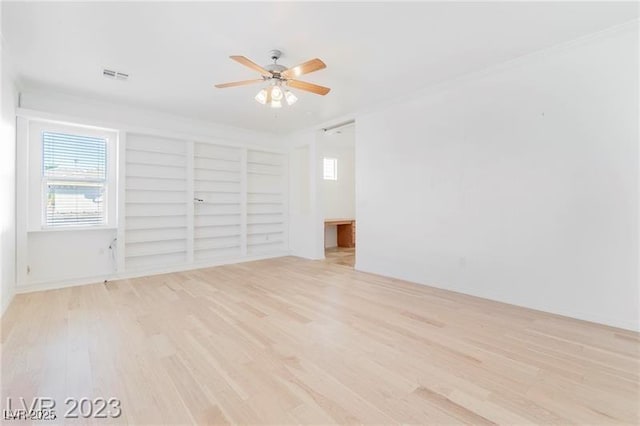 interior space with a ceiling fan, visible vents, and wood finished floors