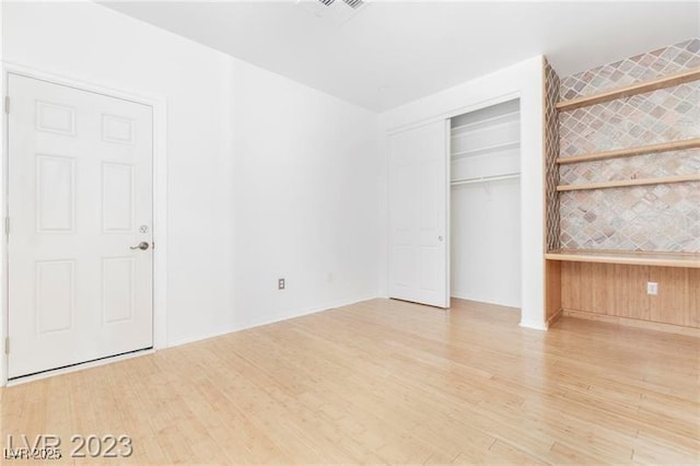 unfurnished bedroom with a closet and wood finished floors