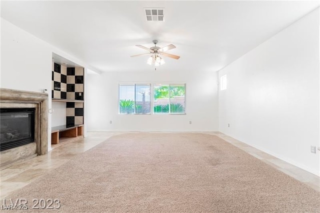 unfurnished living room with a fireplace with flush hearth, visible vents, ceiling fan, and baseboards