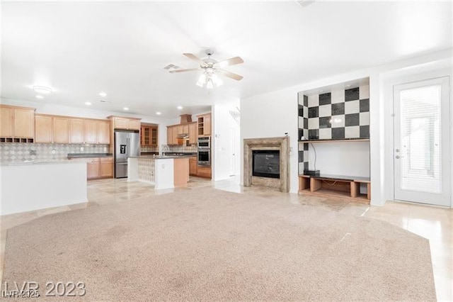 unfurnished living room featuring recessed lighting, a glass covered fireplace, ceiling fan, and a sink