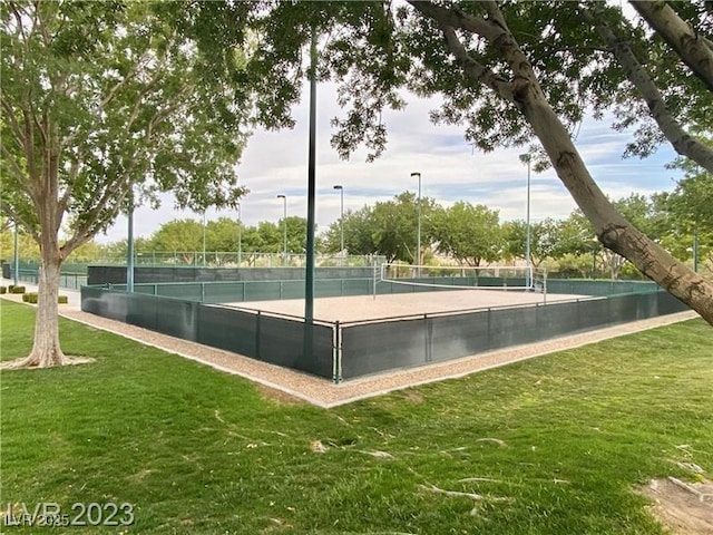 view of tennis court with volleyball court, fence, and a yard