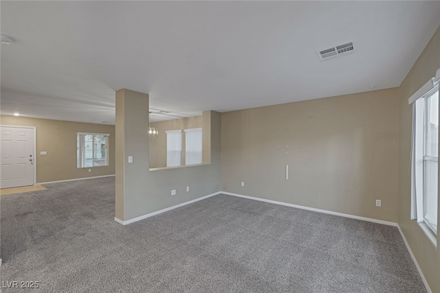 carpeted empty room with visible vents and baseboards