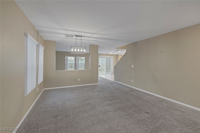 spare room with visible vents, baseboards, and carpet floors