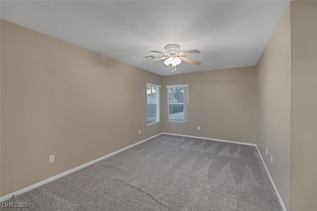 unfurnished room featuring visible vents, baseboards, carpet, and ceiling fan