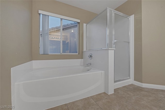 full bath featuring tile patterned flooring, a shower stall, baseboards, and a garden tub