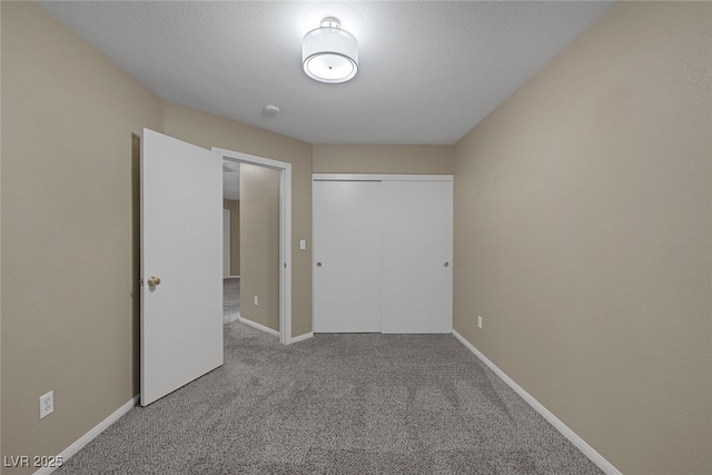 unfurnished bedroom with carpet flooring, baseboards, and a closet