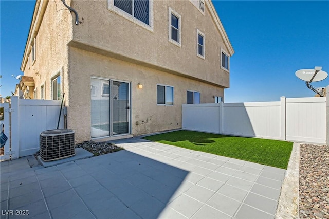 back of property featuring stucco siding, a patio, central AC unit, and a fenced backyard