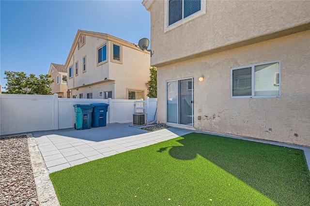 back of house featuring a patio area, stucco siding, a lawn, and a fenced backyard