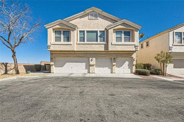 multi unit property featuring stucco siding and an attached garage