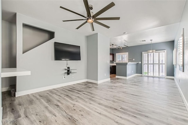 unfurnished living room featuring visible vents, baseboards, light wood-style floors, and ceiling fan