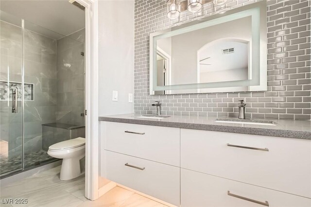 bathroom featuring backsplash, visible vents, marble finish floor, and a sink