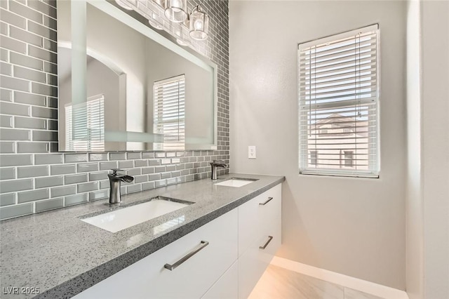 full bathroom with a wealth of natural light, tasteful backsplash, and a sink