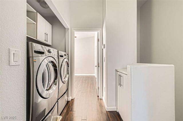 laundry room with cabinet space, independent washer and dryer, dark wood finished floors, and baseboards