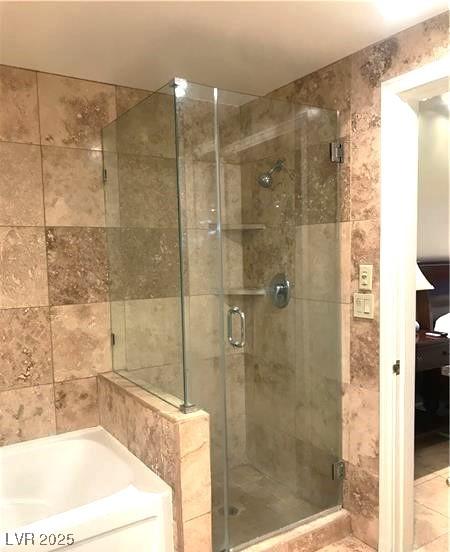 full bathroom featuring a shower stall and a bath