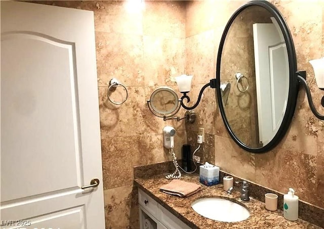 bathroom featuring vanity and tile walls