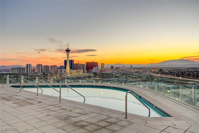 pool at dusk with a city view and a community pool