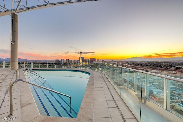 pool at dusk featuring a city view