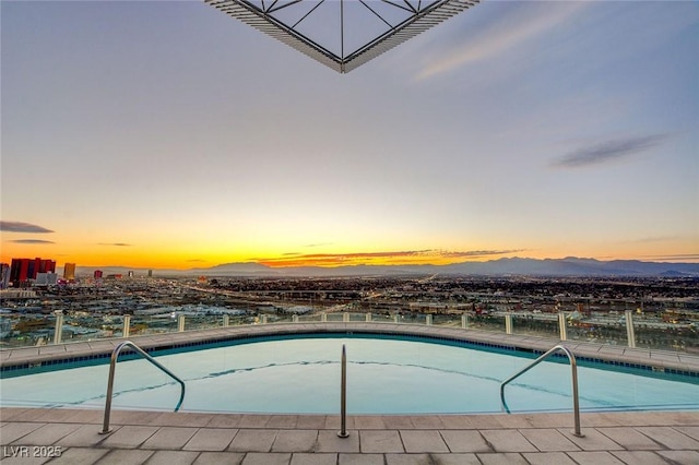 pool at dusk with a mountain view and an outdoor pool