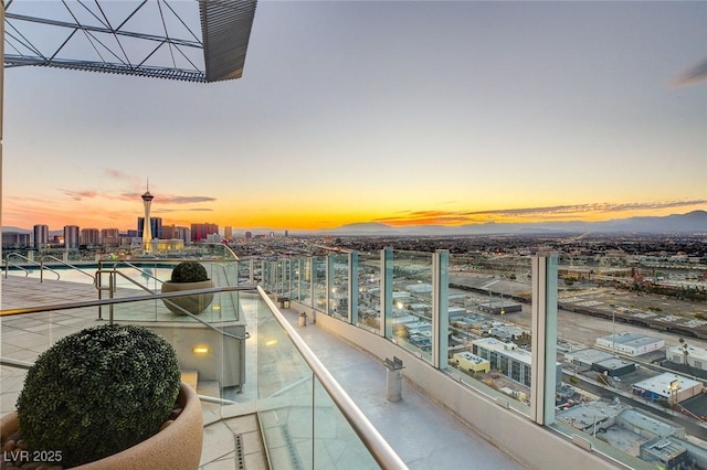 balcony at dusk featuring a city view