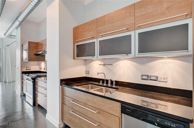 kitchen featuring dark countertops, glass insert cabinets, appliances with stainless steel finishes, exhaust hood, and a sink