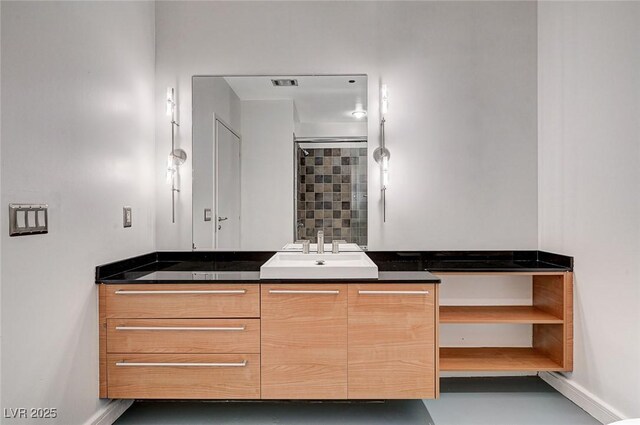 bathroom featuring a shower, baseboards, and vanity