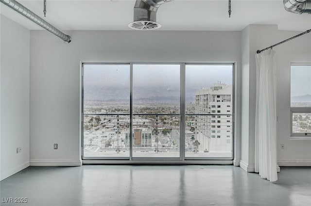 spare room with baseboards and concrete floors