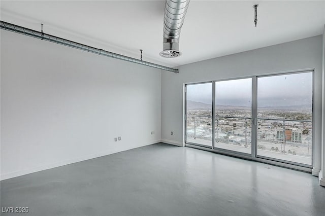 empty room featuring finished concrete flooring and baseboards