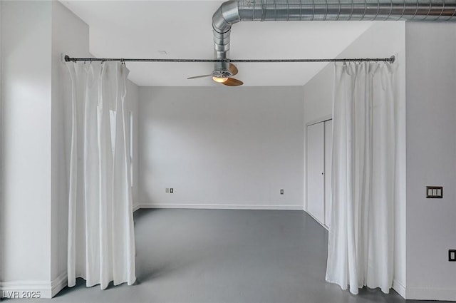 spare room with a ceiling fan, baseboards, and finished concrete floors