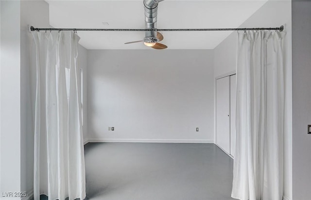 empty room with concrete floors and ceiling fan