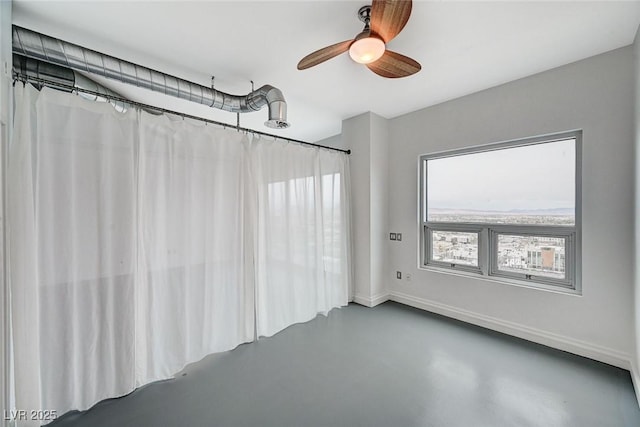 unfurnished room featuring baseboards, concrete flooring, and ceiling fan