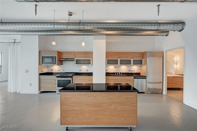 kitchen with finished concrete flooring, a sink, built in appliances, under cabinet range hood, and dark countertops