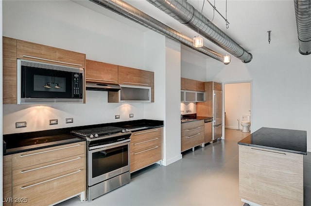 kitchen featuring under cabinet range hood, dark countertops, finished concrete flooring, brown cabinetry, and built in appliances