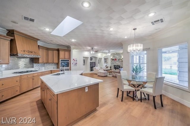 kitchen featuring custom range hood, visible vents, backsplash, and ornamental molding