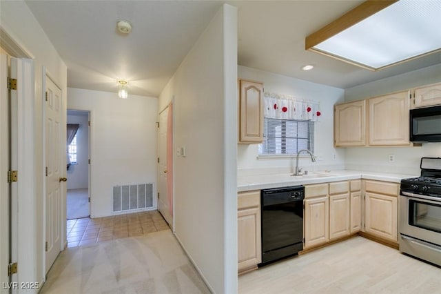 kitchen with black appliances, light brown cabinets, visible vents, and a sink