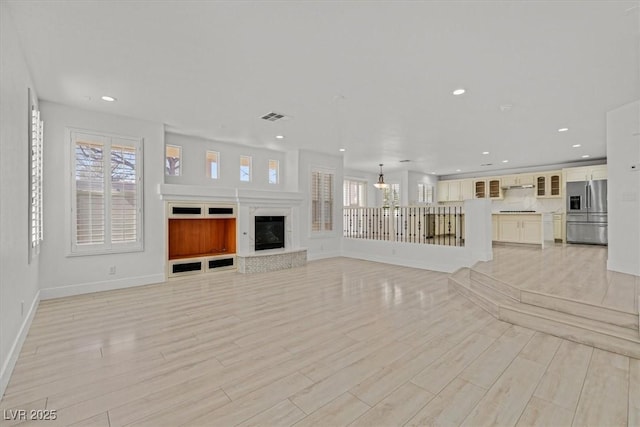 unfurnished living room featuring recessed lighting, visible vents, a healthy amount of sunlight, and light wood-style floors