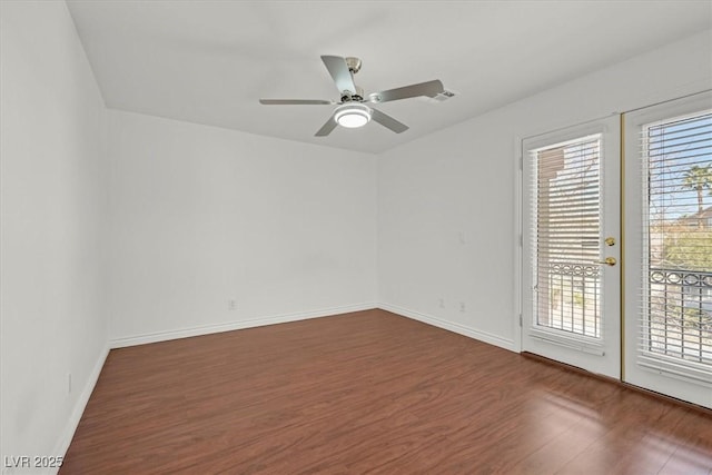 spare room featuring wood finished floors, baseboards, and ceiling fan
