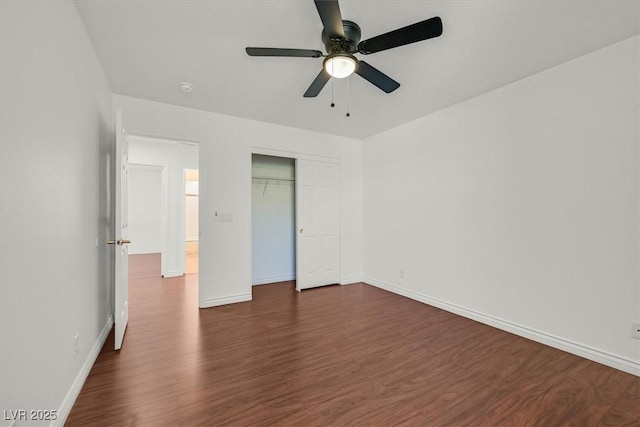 unfurnished bedroom featuring a closet, a ceiling fan, baseboards, and dark wood-style flooring