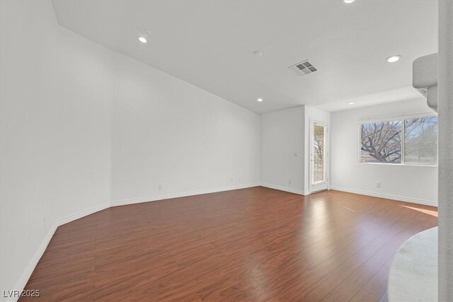 spare room featuring recessed lighting, wood finished floors, visible vents, and baseboards