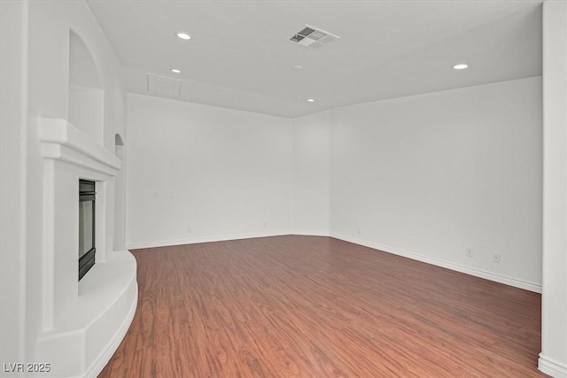 spare room featuring visible vents, recessed lighting, baseboards, and wood finished floors